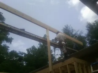 Carpenter setting a ridge beam over a new addition frame — Ice Dam Removal by Roofing Brothers in Belfry