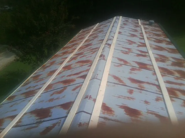 Rusted metal roof panels with new wood purlins before replacement — Storm Damage Roof Repair in Belfry by Roofing Brothers