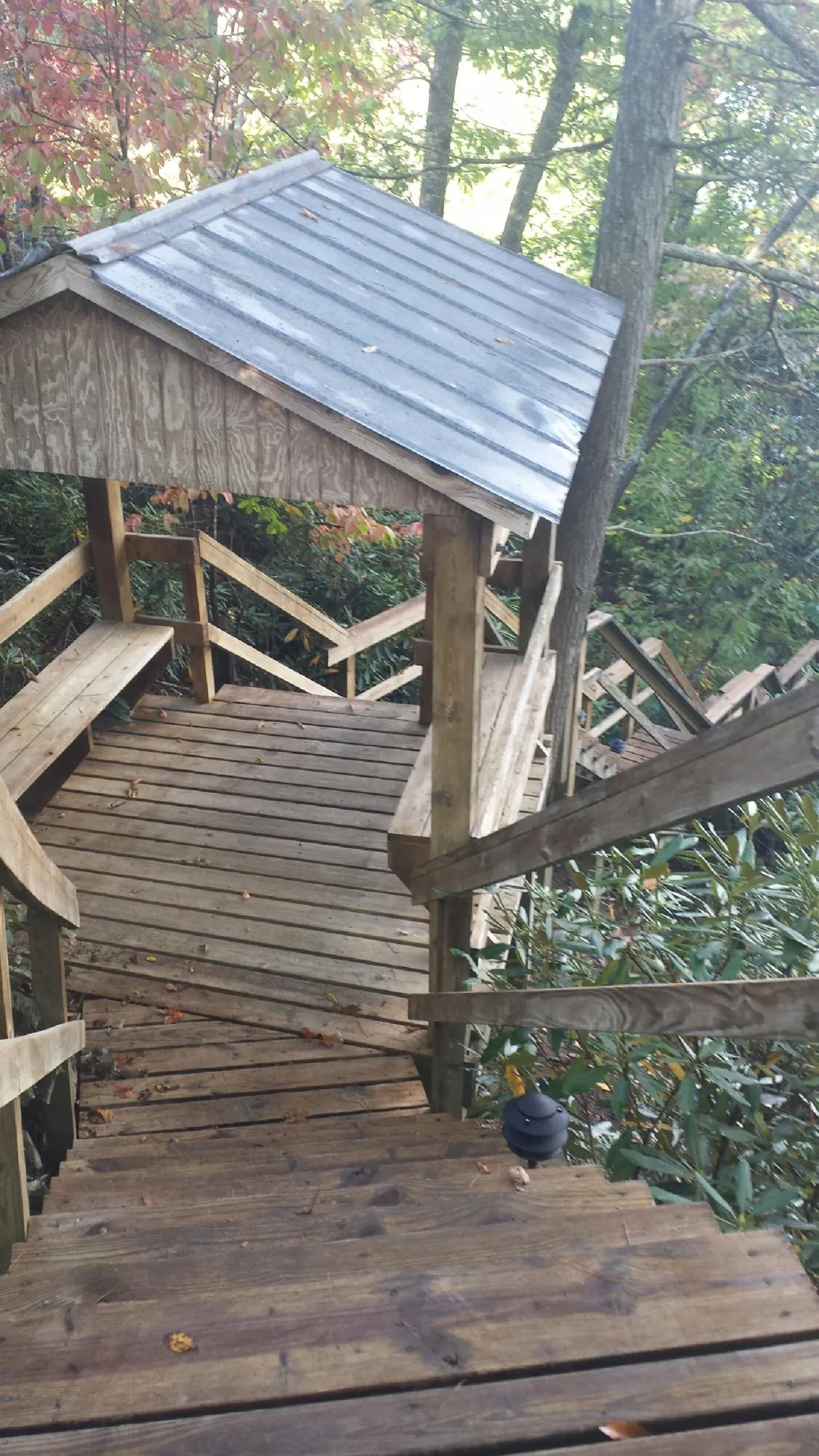 Metal roofed shelter over wooden steps on a wooded walkway — Skylight Repair & Installation work by our crew in Belfry